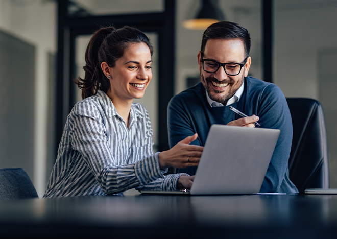 Dwóch specjalistów analizuje materiały szkoleniowe na laptopie - przygotowanie do zmian w ustawie o efektywności energetycznej 2026/2027.